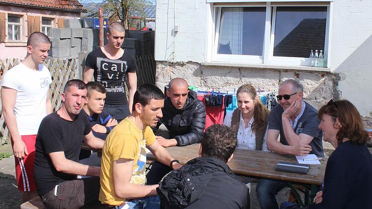Barbara Moritz-Anders, Günter Brehm und Pia Donnert-Brehm (von rechts) aus dem Helferkreis versuchen sich über einen Dolmetscher mit den Flüchtlingen zu verständigen. Foto: Andreas Dorsch