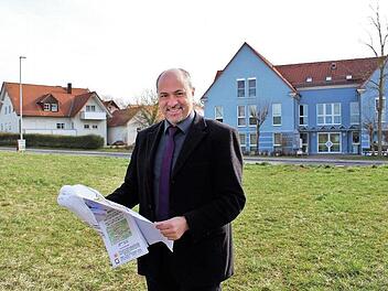 Das Areal an der Bamberger Straße steht nun der Stadt zur Verfügung. In dem blauen Gebäude gegenüber gibt es Ärzte, einen Optiker und eine Bäckerei. Im Bild steht Bürgermeister Johannes Krapp auf dem Baugelände, das die Stadt von den Johannitern gekauft hat. Foto: Evi Seeger