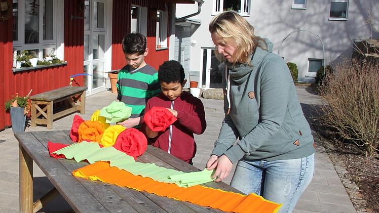 17 Jugendliche aus ganz Süddeutschland leben in drei Wohngruppen in der Gemünder Mühle. Sie waren verhaltensaufällig, hatten Probleme im Sozialverhalten. Hier basteln Rafael und Diego zusammen mit Nadine Zeller, eine von 17 Mitarbeiterinnen, an der Deko für den Tag der offenen Tür. Foto: Ralf Kestel