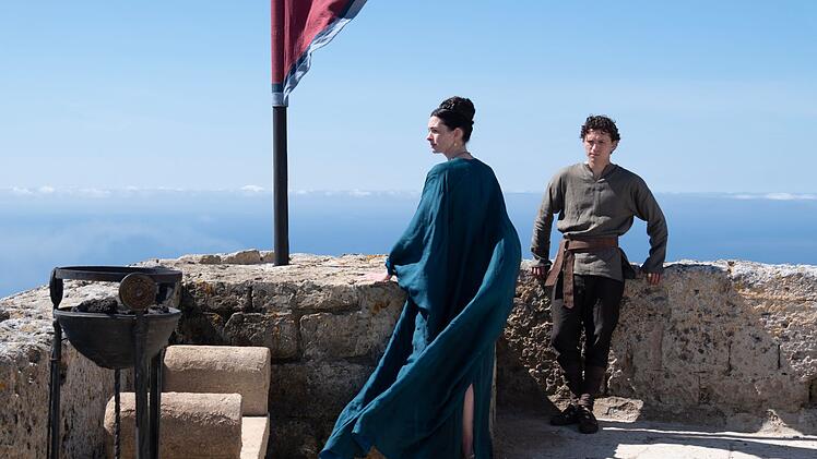 K&ouml;nigin Penelope (Anne Hathaway) und ihr Sohn Telemachos (Tom Holland) fragen sich, wo Odysseus wohl bleiben mag.