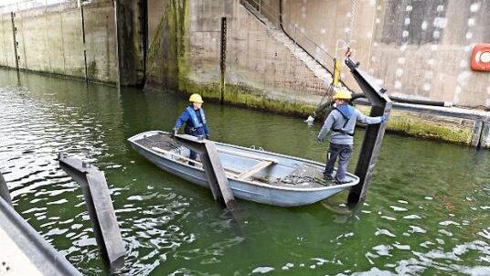 Zwei Männer auf einem Boot helfen beim Einfädeln der Stützen.  Foto: Ronald Rinklef