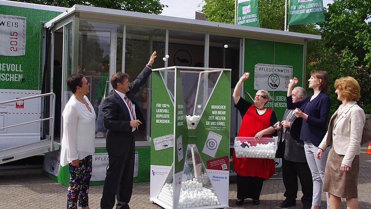 Vor der großen Sanduhr des Pflegetrucks machen (v. l.) Daniela Wölfel, MdL Hermann Imhof, Cornelia Thron, Heinz Hausmann, MdB Emmi Zeulner und Karin Pfadenhauer mit weißen Bällen klar, wie knapp die Zeit in der Pflege ist. Foto: Heike Schülein