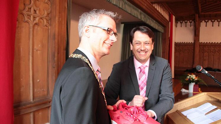 Genosse Reiner Büttner (rechts) überreichte dem SPD-Oberbürgermeister Uwe Kirschstein für die neue Laufbahn rote Laufschuhe.