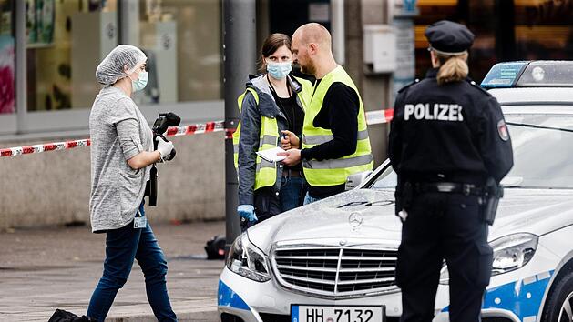 Polizeibeamte sichern am 28.07.2017 in Hamburg Spuren vor einem Supermarkt, in dem am Nachmittag ein Mann eine Person t&ouml;tete und vier verletzte. Der mutma&szlig;liche T&auml;ter wurde verletzt festgenommen. Foto: Markus Scholz/dpa