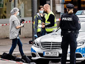 Polizeibeamte sichern am 28.07.2017 in Hamburg Spuren vor einem Supermarkt, in dem am Nachmittag ein Mann eine Person tötete und vier verletzte. Der mutmaßliche Täter wurde verletzt festgenommen. Foto: Markus Scholz/dpa