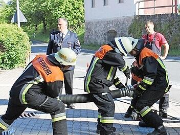 Die Egloffsteiner Feuerwehrleute hantieren an einem Schlauch.