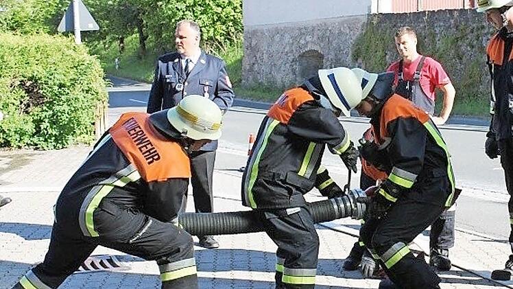 Die Egloffsteiner Feuerwehrleute hantieren an einem Schlauch.