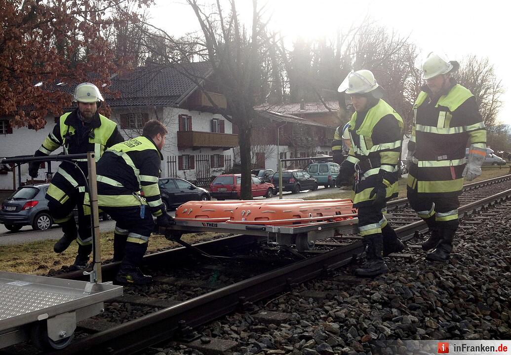 Feuerwehrleute transportieren am 09.02.2016 Rettungsgerät zur Unfallstelle eines Zugunglücks in der Nähe von Bad Aibling (Bayern). Bei einem schwerem Zugunglück in Oberbayern sind mehrere Menschen ums Leben gekommen. Foto: Paul Winterer/dpa