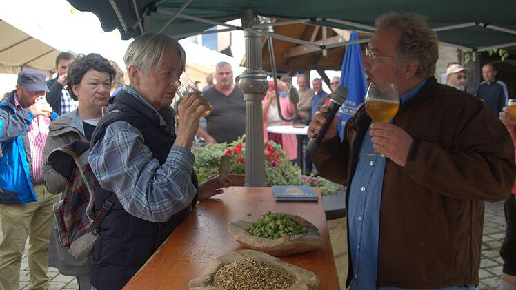 Auf reges Interesse stieß die Verkostung von fünf Bieren aus dem Rodachtal, die Biersommelier Markus Raupach (vorn) auf Einladung der Initiative Rodachtal am Samstag beim Brauhausfest in Unterelldorf anbot. Als erstes wurde das Hausbräu aus dem Seßlacher Kommunbrauhaus vorgestellt. Bevor sie das Bier schmeckten, fragte Raupach Test-Trinker wie Angela Francisca Endress (Seßlach, links), welches Aromanoten sie riechen könnten. Stefan Pachsteffl von den Seßlacher Brauhausfreunden (rechts) hörte ...