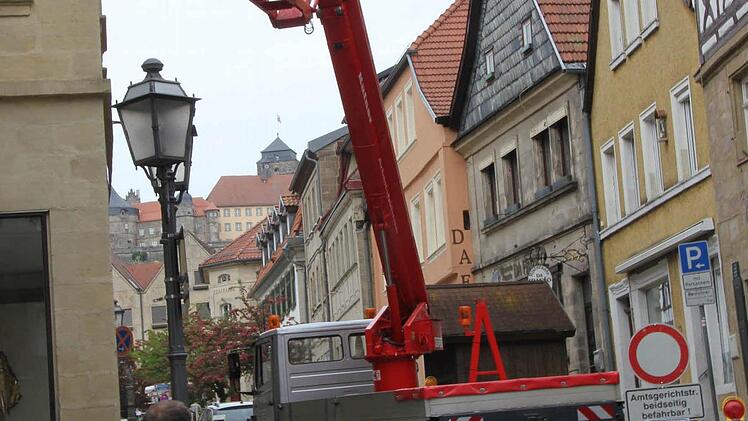 Klaus Metzler hängt das "Kronach leuchtet"-Transparent mittels Hebebühne am Eingang der Lucas-Cranach-Straße auf.