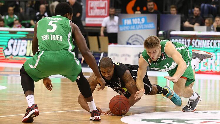 Ronald Burrell (Mitte) und der Trierer Mathis Moenninghoff hechten nach dem Ball.