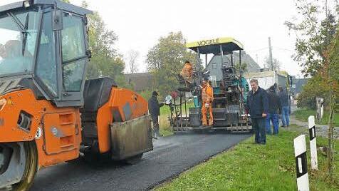 Bürgermeister Siegfried Beyer machte sich am Vormittag persönlich ein Bild von den laufenden Asphaltierungsarbeiten des Bautrupps der Guttenberger Straßenbaugesellschaft an der Straße Wustuben-Elbersreuth. Foto: Klaus-Peter Wulf