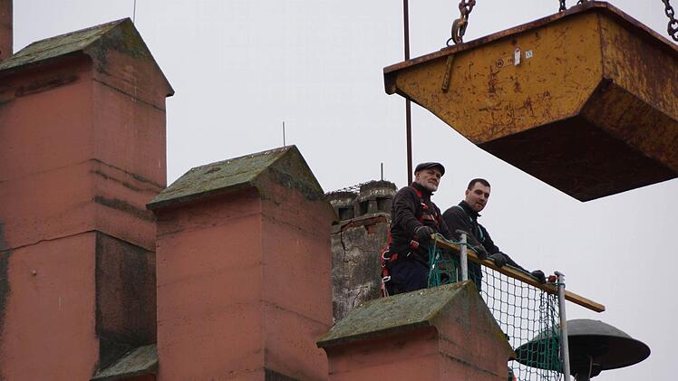 In luftiger Höhe: Bauhofmitarbeiter bereiten den Abriss des hinteren Kamins vor. Foto: Arkadius Guzy