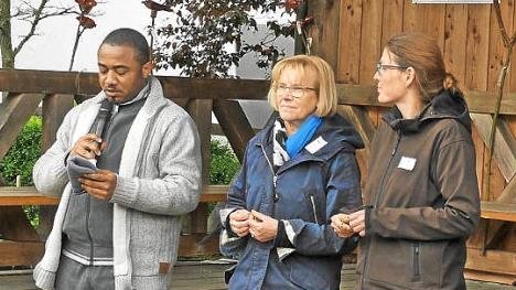 Kaplan Ferdinand Mba (links) spricht ein Segenswort. Neben ihm Walburga Albert und Barbara Mildenberger vom Kolumbienkreis.