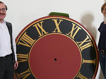 Pfarrer Walter Ries und Kirchenpflegerin Elisabeth Knauer zeigen das Zifferblatt der Turmuhr, das bereits restauriert ist. Foto: Marion Krüger-Hundrup