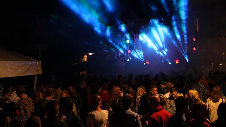 Stadtfest Bad Brückenau 2015: Vor der Jugendbühne in der Altstadt drängen sich die Leute, während eine Laser-Show den Nachthimmel mit bunten Farben beleuchtet. Foto: Friedemann Müller