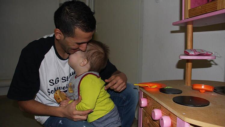 Kochen ist Frauensache? Von wegen! Die beiden Männer der Familie Faraj vor dem Spielzeugherd, der der Flüchtlingsunterkunft gespendet wurde.