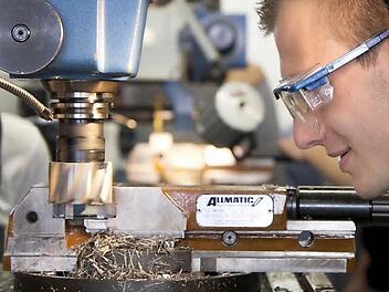 Tobias Schmitt, Bosch-Mitarbeiter im ersten   Ausbildungsjahr, betrachtet im Bamberger Ausbildungszentrum die Arbeitsweise einer Fräsmaschine. Er ist einer von rund 300 Azubis am Standort. Foto: Michael Gründel