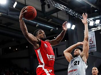 Neuzugang Retin Obasohan, der bei seinem Debüt im Brose-Trikot für knapp 17 Minuten auf dem Feld stand, setzt zum Dunking an; rechts der Gießener Jordan Barnett Foto: Daniel Löb.