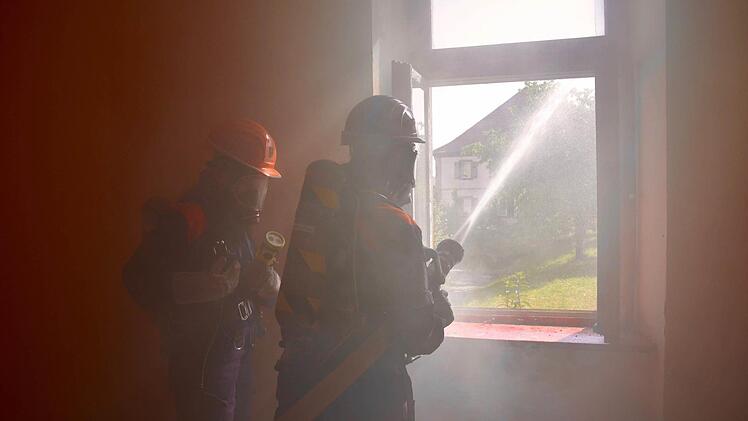Wohnhausbrand in Waldfenster: Die Atemschutzgeräteträgerinnen Lisa Schlereth und Vanessa Karch bekämpfen hier das Feuer im Erdgeschoss der Alten Schule. Foto: Kathrin Kupka-Hahn