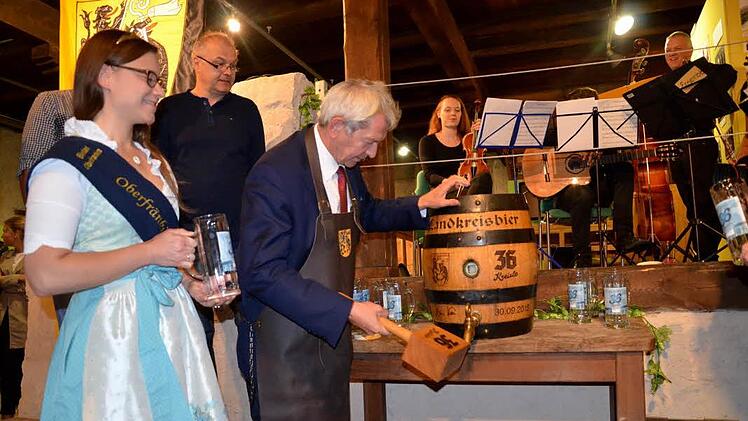 Unter den Augen der oberfränkischen Bierkönigin Christina Pollnick sticht Landrat Johann Kalb ein Bierfass mit "36 Kreisla" an.  Foto: Andrea Spörlein