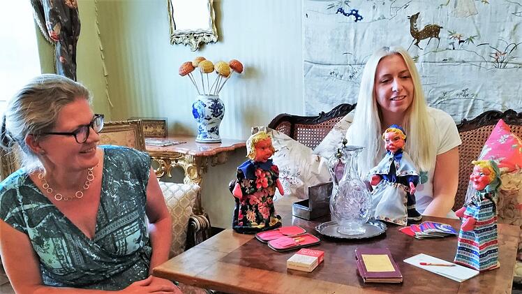 Die Tauschpartnerinnen Anja Lippert (links; Museen der Stadt Aschaffenburg) und Josephine Glöckner (Museen Schloss Aschach) im Spielsalon des Aschacher Schlosses mit Handpuppen aus dem Aschaffenburger Museumsfundus.