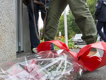Ein kleiner Blumenstrauß liegt vor dem Eingang eines Hauses in der Plattenbausiedlung in Suhl Hier wurden am Dienstagmorgen zwei Kinderleichen gefunden. Fotos: Michael Reichel/dpa