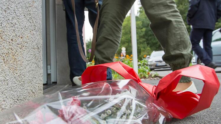 Ein kleiner Blumenstrauß liegt vor dem Eingang eines Hauses in der Plattenbausiedlung in Suhl Hier wurden am Dienstagmorgen zwei Kinderleichen gefunden. Fotos: Michael Reichel/dpa