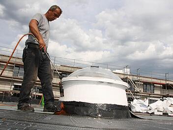 Arbeiter verschweisen die Bahnen auf dem Flachdach. Foto: Ralf Ruppert
