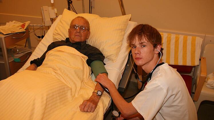 Fabian Götz misst Dr. Hermann Reheusser den Blutdruck. Nach drei Jahren  ist die Ausbildung zum Krankenpfleger abgeschlossen.