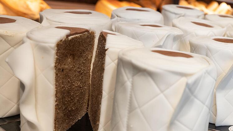 Eine aufgeschnittener ·Klopapier-Kuchen· steht im Verkaufsraum auf einem Blech. Der runde Marmorkuchen sieht mit Fondant umwickelt wie Toilettenpapier-Rollen aus. Der Klopapier-Kuchen von Bäcker Kortüm ist in der Corona-Krise zu einem ·Bestseller· geworden. Foto: Bernd Thissen/dpa