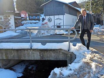 Die Brücke über den Kleinen Buchbach in Friedersdorf wird im Rahmen der Dorferneuerung erneuert. Sie ist ein Schlüsselobjekt zur Verkehrserschließung des oberen Dorfes. Bürgermeister Pietz (Bild) erklärt, dass auch die Straße dort für Busse und Lkw verbreitert werden müsse. Foto: K.- H. Hofmann