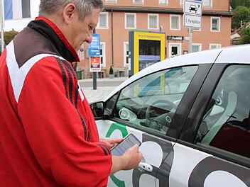 Manfred Käferlein gehört zu den Kunden von Easy drive. Über eine Smartphone-App kann er die Tür des Renault Zoe öffnen, der an der Ladestation am Eku-Parkplatz steht. Foto: Alexander Hartmann