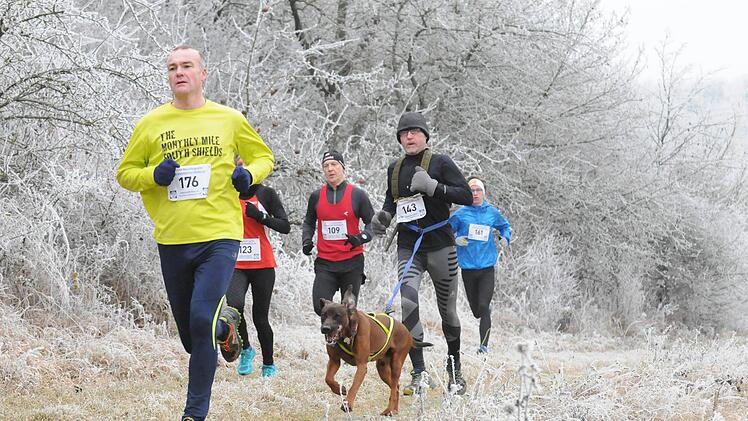 Ein Exot führt diese Gruppe an: Aus Wales stammt Kelsham Hanna (links), der Gesamt-13. wurde. Mit Hund zum Fuschter Silvesterlauf gekommen war Egon Schmidt aus Hassenbach. Verdeckt im Bild: Frauen-Gesamtsiegerin Anna Roth (123) vom TV/DJK Hammelburg. Foto: ssp