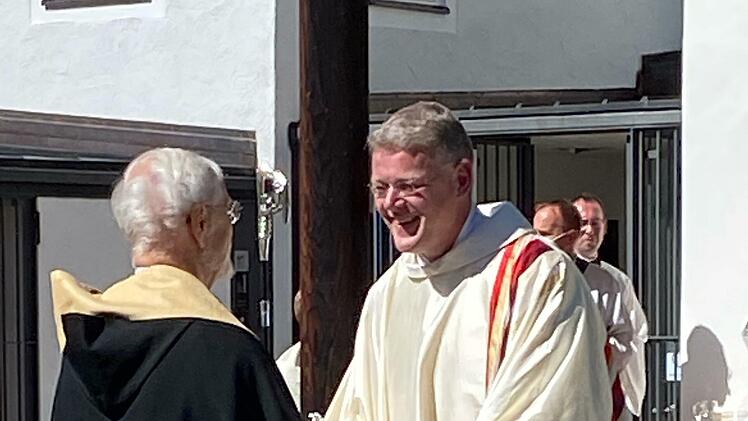Ein Mitbruder gratuliert Christian Rentsch zur Priesterweihe. Foto: Christine Neely