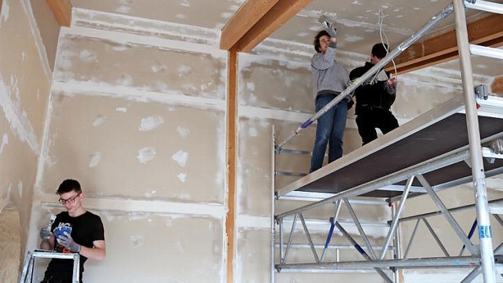 Linus, Julian und Tim spachteln die Gipsplatten. Foto: Johanna Blum