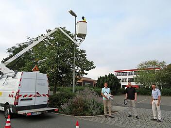 Die Umrüstung der Straßenbeleuchtung startet: Oben auf der Arbeitsbühne tauscht Ivo Juzel Alt gegen Neu. Welche Ersparnis das bringt, erklärten (von links) Anton Schatz, Dominic Tschampe  und Burkhard Butz. Foto: Monika Schütz