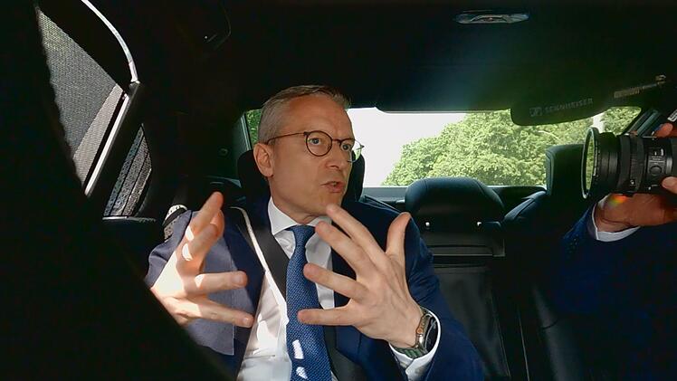 Digitalminister Karsten Wildberger (CDU) sitzt auf R&uuml;cksitz eines Dienstwagens und erkl&auml;rt seine Sichtweise.