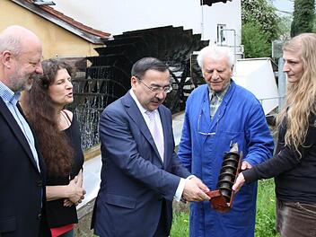 Besichtigung der "Rödermühle" (von links): Hans-Josef Fell, Christa Schmitt, Dr. Nurlan Onzhanov, Otmar Huppmann und Lisa Schmitt. Wie wird mit Wasserkraft Strom erzeugt? Der Botschafter lässt sich das Prinzip an einem Modell erläutern.  Fotos: Markus Reeh