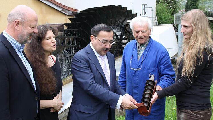 Besichtigung der "Rödermühle" (von links): Hans-Josef Fell, Christa Schmitt, Dr. Nurlan Onzhanov, Otmar Huppmann und Lisa Schmitt. Wie wird mit Wasserkraft Strom erzeugt? Der Botschafter lässt sich das Prinzip an einem Modell erläutern.  Fotos: Markus Reeh