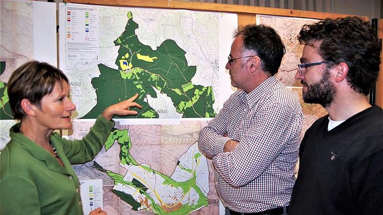 Doris Pokorny, stellvertretende Leiterin der Verwaltungsstelle des Biosphärenreservats Rhön, vor einer topographischen Landkarte im Gespräch mit dem Bamberger Geographen Armin Röhrer (Mitte) und Landschaftsplaner Thomas Büttner aus Morschen (Hessen). Foto: Sigismund von Dobschütz