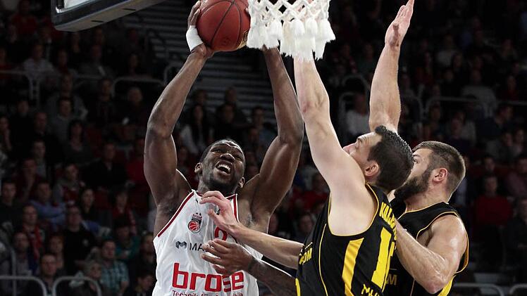 Mit allem, was sie haben, werden sich die Ludwigsburger den Bambergern in den Weg stellen. Hier versuchen Adam Waleskowski (M.) und Jon Brockman (r.) Brose-Center Trevor Mbakwe am Korberfolg zu hindern.  Foto: sportpress