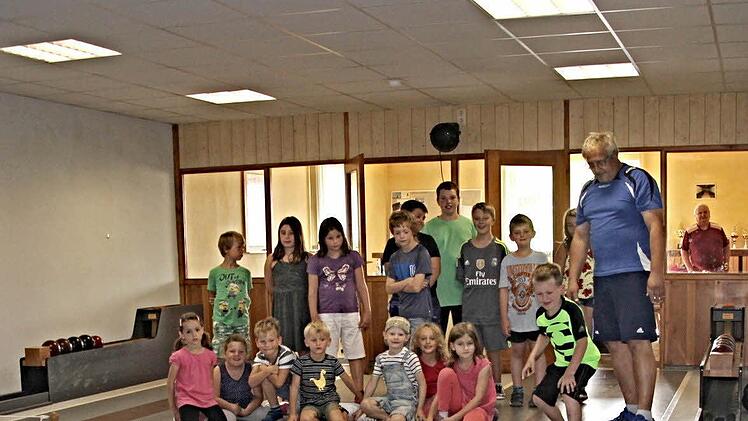 Mächtig ins Zeug legt sich der sechsjährige Moritz aus Unterpreppach als er die Kugel auf die Bahn schickt. Im Hintergrund weitere Teilnehmer des Ferienprogramms und rechts der Vorsitzende des Kegelsportclubs KSV Waldeck, Jürgen Oppelt. Foto: Helmut Will