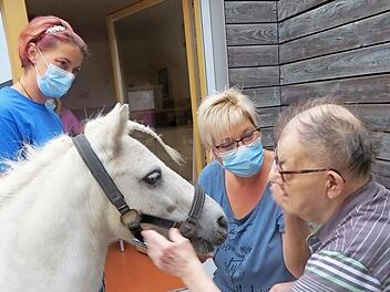 Auch f&uuml;r diesen Bewohner des Sozialpsychiatrischen Zentrums der Diakonie war die Begegnung mit den Ponys ein wunderbares Erlebnis: Bettina R&ouml;ckelein (Mitte) organisierte den besonderen Besuch im Sozialpsychiatrischen Zentrum in Ebern.  Foto: Diakonie Bamberg-Forchheim