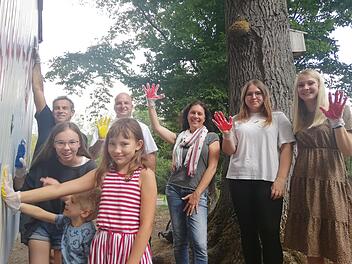 Hannah, Luis und Emilia machen es vor, wie man seinen Händeabdruck auf dem Bauwagen verewigen kann. Arno Reuscher, Michaek Kastl, Christine Schikora, Lara Reuß und Martina Rauh (hinten von links) machen ihnen es dann nach. Fotro: Heike Beudert