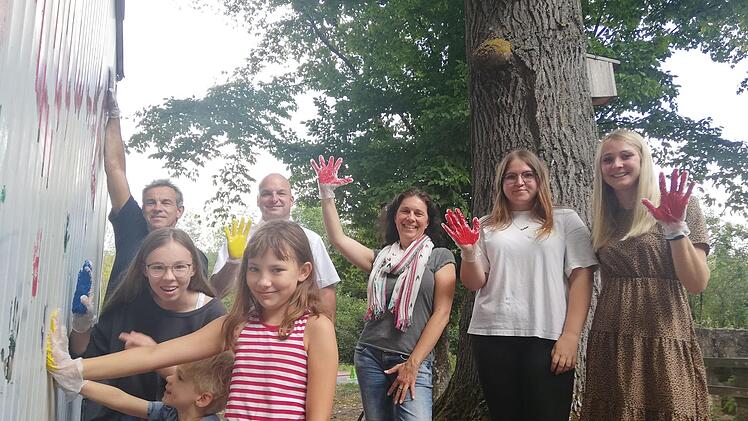 Hannah, Luis und Emilia machen es vor, wie man seinen Händeabdruck auf dem Bauwagen verewigen kann. Arno Reuscher, Michaek Kastl, Christine Schikora, Lara Reuß und Martina Rauh (hinten von links) machen ihnen es dann nach. Fotro: Heike Beudert