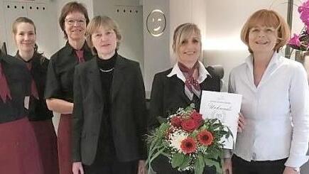 Die Jubilarin Ines Dobmeier (mit Blumenstrau&szlig;) wurde im Kreise der Mitarbeiter von Gesch&auml;ftsf&uuml;hrerin Gisela Gutwill (rechts) geehrt. Foto: pr