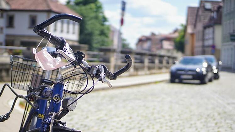 Eine Straßenszene im Corona-Sommer: Der Mund-Nasen-Schutz lüftet kurz durch. Ist das die Ruhe vor dem Sturm? Foto: Bastian Sünkel