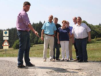 Auf Holperpisten unterwegs: Alexander Schneider, Bürgermeister von Geroda, zeigt seinen Kollegen der Brückenauer Rhönallianz Schlaglöcher auf einem Verbindungsweg in den Schwarzen Bergen. Foto: Ulrike Müller
