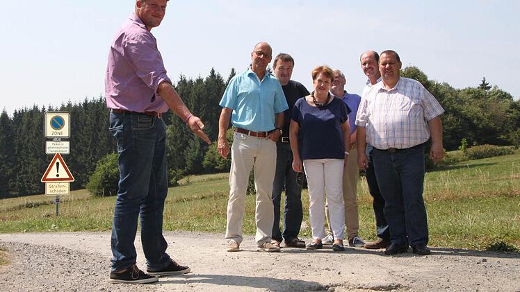 Auf Holperpisten unterwegs: Alexander Schneider, Bürgermeister von Geroda, zeigt seinen Kollegen der Brückenauer Rhönallianz Schlaglöcher auf einem Verbindungsweg in den Schwarzen Bergen. Foto: Ulrike Müller